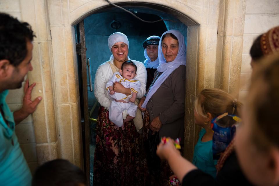 Лалиш, Ирак - 28 мая 2017: Семья езидов проводит обряд посвящения младенца в Езидизм в Священном Лалише, Ирак. Езиды - это курдское религиозное меньшинство, коренное население северной Месопотамии. GETTY